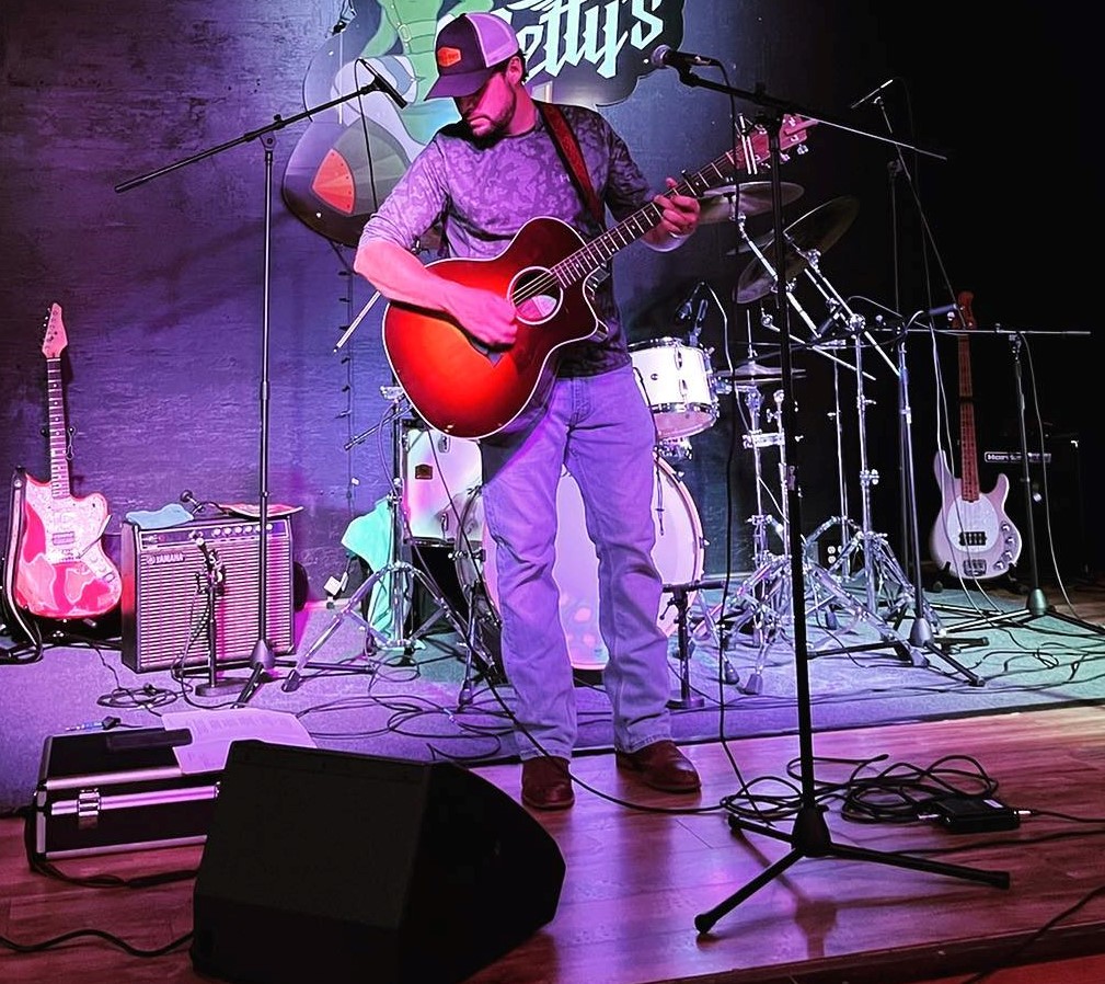 George Maddox on stage playing guitar