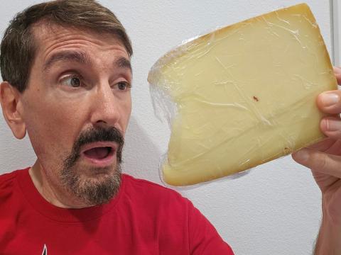 Bruce Wawrzyniak holding up the cheese he bought at a craft fair