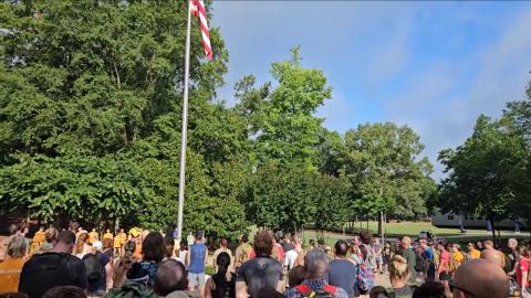 A crowd stands and looks up at the American flag during the national anthem A crowd stands and looks up at the American flag during the national anthem