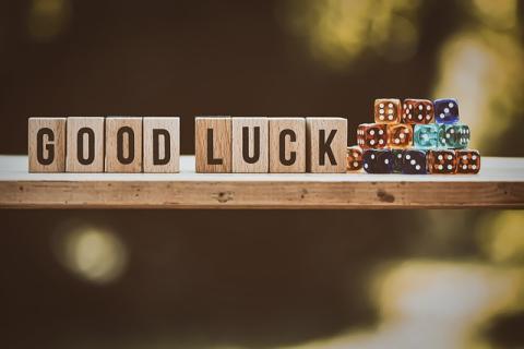 Wooden blocks spelling GOOD LUCK next to dice pile Wooden blocks spelling GOOD LUCK next to dice pile