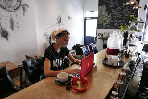 Girl with laptop sitting at the counter in a coffee shop