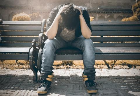 Guy on bench with head in hands