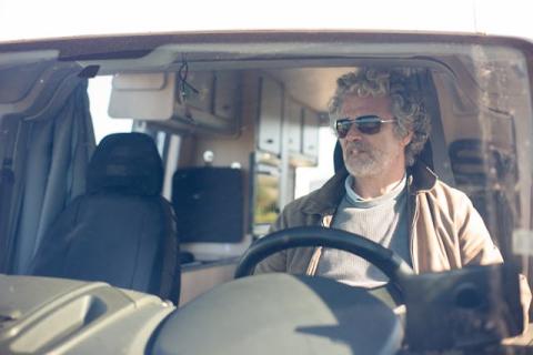 Man wearing sunglasses driving a conversion van Man wearing sunglasses driving a conversion van