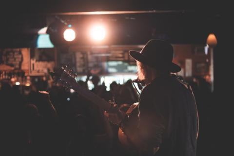 Girl on stage performing to a crowd Girl on stage performing to a crowd