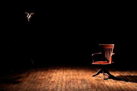 A chair on an empty dark stage A chair on an empty dark stage