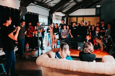 A group listens to a speaker at a networking event A group listens to a speaker at a networking event
