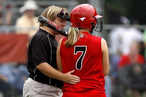 Coach with arm around softball player